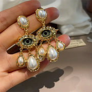 Unique eye and pearl drop earrings, ideal for jewelry storage, jewelry websites, vintage jewelry collections, and bold statement fashion for jewelry lovers.
