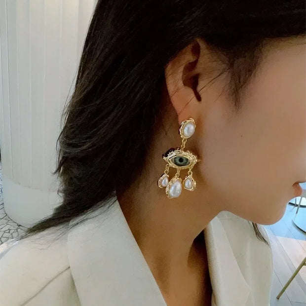 Unique eye and pearl drop earrings, ideal for jewelry storage, jewelry websites, vintage jewelry collections, and bold statement fashion for jewelry lovers.