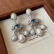 Unique eye and pearl drop earrings, ideal for jewelry storage, jewelry websites, vintage jewelry collections, and bold statement fashion for jewelry lovers.