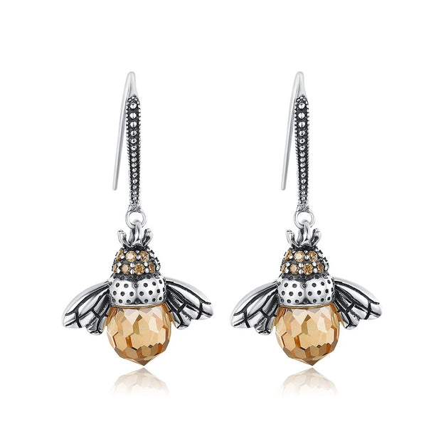 Bee-themed drop earrings with amber crystals and silver details, perfect for jewelry websites, jewelry storage, vintage jewelry, and nature-inspired fashion.