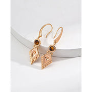Vintage-inspired gold drop earrings with gemstones, ideal for earrings piercing, jewelry storage in a jewelry case, and perfect for jewelry designers and jewelry websites.