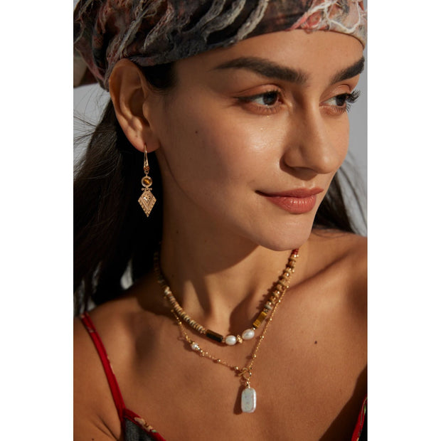 Vintage-inspired gold drop earrings with gemstones, ideal for earrings piercing, jewelry storage in a jewelry case, and perfect for jewelry designers and jewelry websites.