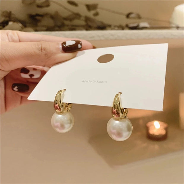 Elegant gold pearl hoop earrings for jewelry designers, perfect for jewelry storage or display in a jewelry case, ideal for body jewelry or vintage jewelry websites.