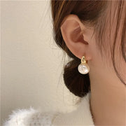 Elegant gold pearl hoop earrings for jewelry designers, perfect for jewelry storage or display in a jewelry case, ideal for body jewelry or vintage jewelry websites.