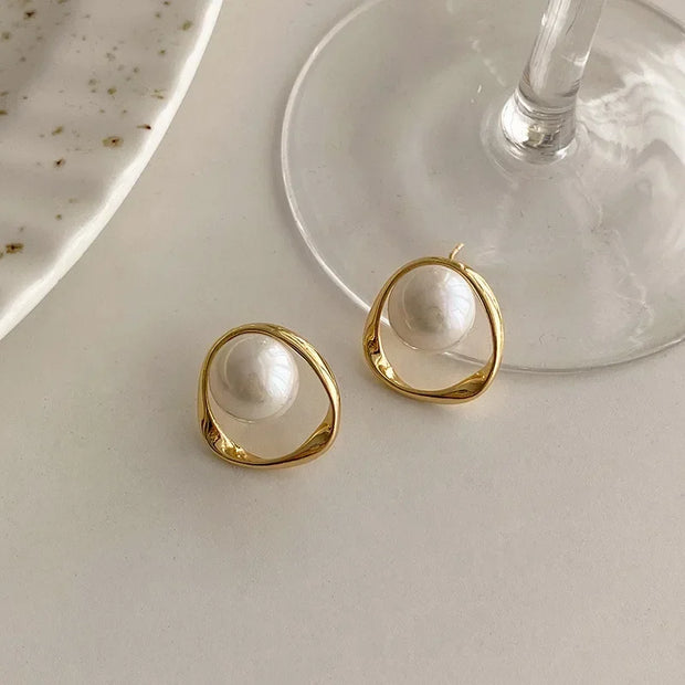 Elegant gold pearl stud earrings, perfect for jewelry cleaning, jewelry storage, jewelry websites, or featuring as a timeless piece by top jewelry designers.