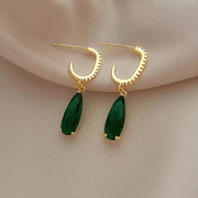 Elegant gold teardrop earrings with vibrant green gemstones and diamond accents, showcasing stunning craftsmanship by jewelry designers, ideal for vintage jewelry lovers.