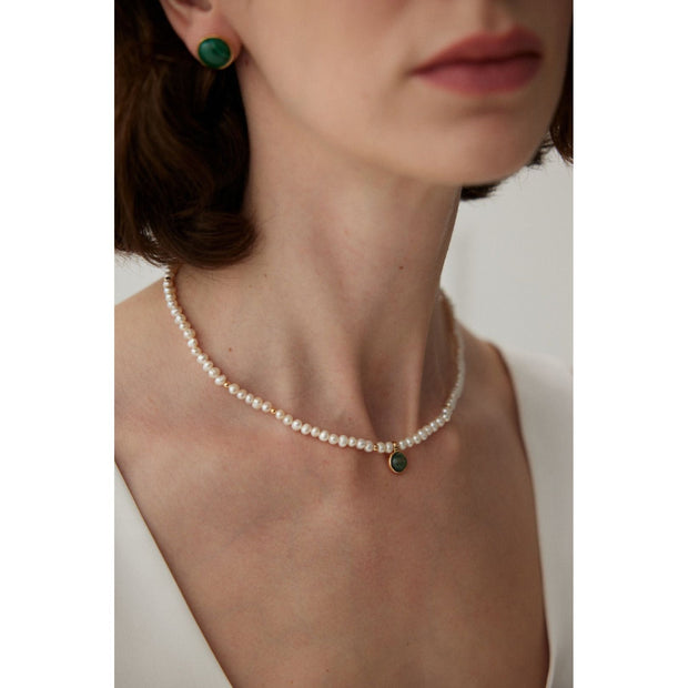 Elegant pearl necklace with gold accents and green gemstone pendant, perfect for vintage jewelry collections, jewelry storage, jewelry for mom, and jewelry cleaning.