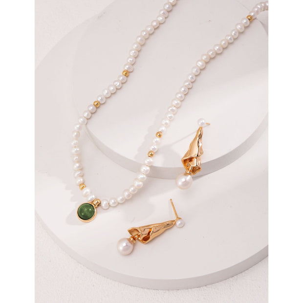 Elegant pearl necklace with gold accents and green gemstone pendant, perfect for vintage jewelry collections, jewelry storage, jewelry for mom, and jewelry cleaning.