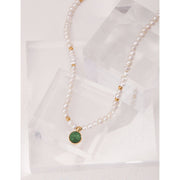 Elegant pearl necklace with gold accents and green gemstone pendant, perfect for vintage jewelry collections, jewelry storage, jewelry for mom, and jewelry cleaning.