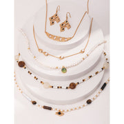 Elegant pearl necklace with gold accents and green gemstone pendant, perfect for vintage jewelry collections, jewelry storage, jewelry for mom, and jewelry cleaning.