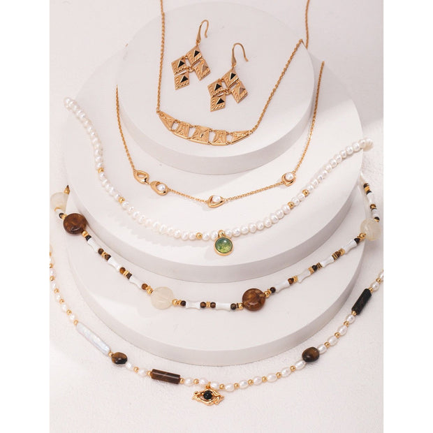 Elegant pearl necklace with gold accents and green gemstone pendant, perfect for vintage jewelry collections, jewelry storage, jewelry for mom, and jewelry cleaning.