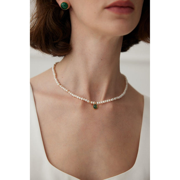 Elegant pearl necklace with gold accents and green gemstone pendant, perfect for vintage jewelry collections, jewelry storage, jewelry for mom, and jewelry cleaning.