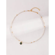 Elegant pearl necklace with gold accents and green gemstone pendant, perfect for vintage jewelry collections, jewelry storage, jewelry for mom, and jewelry cleaning.
