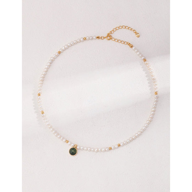 Elegant pearl necklace with gold accents and green gemstone pendant, perfect for vintage jewelry collections, jewelry storage, jewelry for mom, and jewelry cleaning.