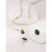 Elegant pearl necklace with gold accents and green gemstone pendant, perfect for vintage jewelry collections, jewelry storage, jewelry for mom, and jewelry cleaning.