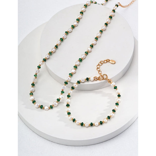 Elegant pearl and green crystal bracelet with gold chain, perfect for jewelry storage in a jewelry case. A timeless design for jewelry websites and jewelry lovers, offering classic beauty for mature women hairstyles. Ideal for earrings and rings collections, this jewelry features turquoise accents and a vintage touch. Perfect for jewelry repair close to me or for adding to a jewelry for mom collection. With gemstones like turquoise and emerald, this is a stunning piece for those looking for permanent jewelr