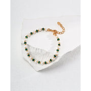 Elegant pearl and green crystal bracelet with gold chain, perfect for jewelry storage in a jewelry case. A timeless design for jewelry websites and jewelry lovers, offering classic beauty for mature women hairstyles. Ideal for earrings and rings collections, this jewelry features turquoise accents and a vintage touch. Perfect for jewelry repair close to me or for adding to a jewelry for mom collection. With gemstones like turquoise and emerald, this is a stunning piece for those looking for permanent jewelr