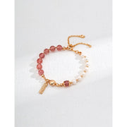 Elegant pink bead and pearl bracelet with a gold chain and engraved charm, ideal for jewelry storage in a jewelry case. Perfect for jewelry designers, gem jewelry, or jewelry websites. A timeless piece for vintage jewelry lovers, jewelry brands, or permanent jewelry seekers.