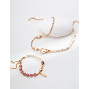 Elegant pink bead and pearl bracelet with a gold chain and engraved charm, ideal for jewelry storage in a jewelry case. Perfect for jewelry designers, gem jewelry, or jewelry websites. A timeless piece for vintage jewelry lovers, jewelry brands, or permanent jewelry seekers.