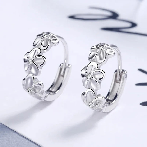 Elegant silver floral hoop earrings with crystals, perfect for earrings piercing and earrings rings collections. Ideal for jewelry storage, jewelry websites, and vintage jewelry lovers.
