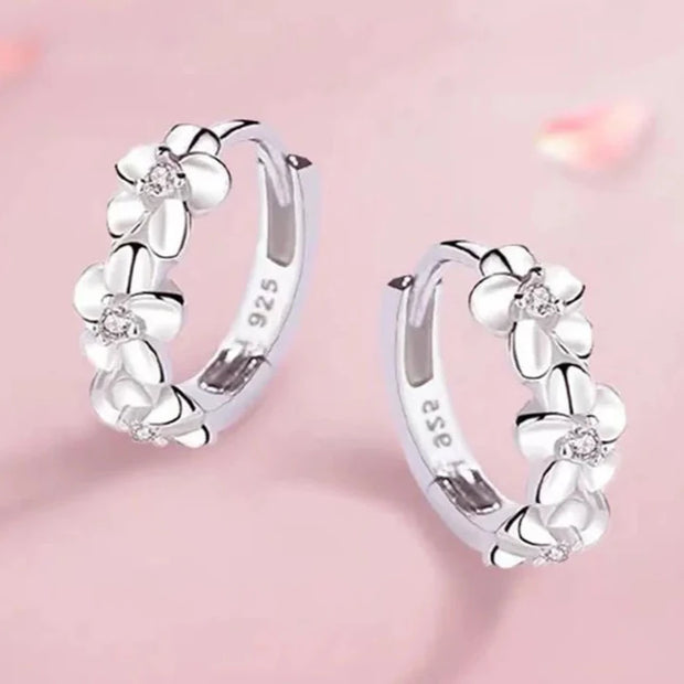 Elegant silver floral hoop earrings with crystals, perfect for earrings piercing and earrings rings collections. Ideal for jewelry storage, jewelry websites, and vintage jewelry lovers.