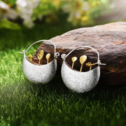 Elegant silver and gold leaf earrings showcasing unique jewelry designers' artistry, perfect for vintage jewelry websites, jewelry storage, and gift for mom.
