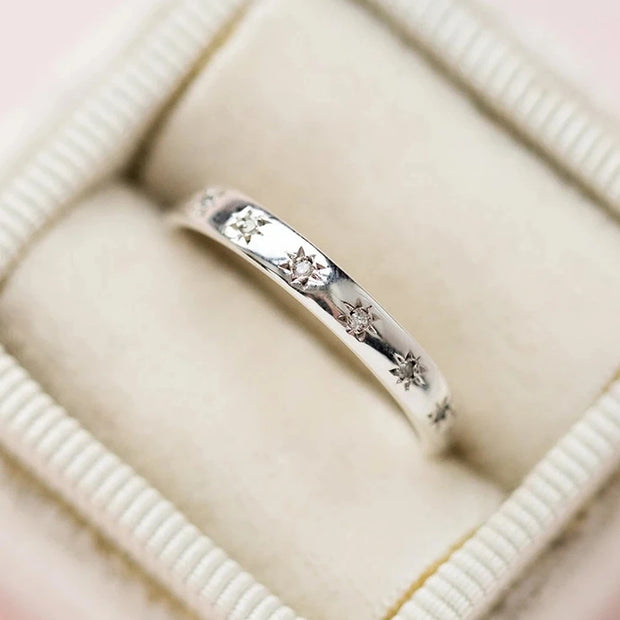 Gold band ring with star-shaped diamond engravings, perfect for jewelry designers, vintage jewelry collections, or jewelry websites specializing in elegant body jewelry.