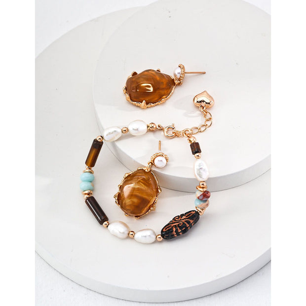 Gold drop earrings with amber stones and pearls, perfect for vintage jewelry lovers, jewelry designers, and jewelry storage ideas on top jewelry websites.