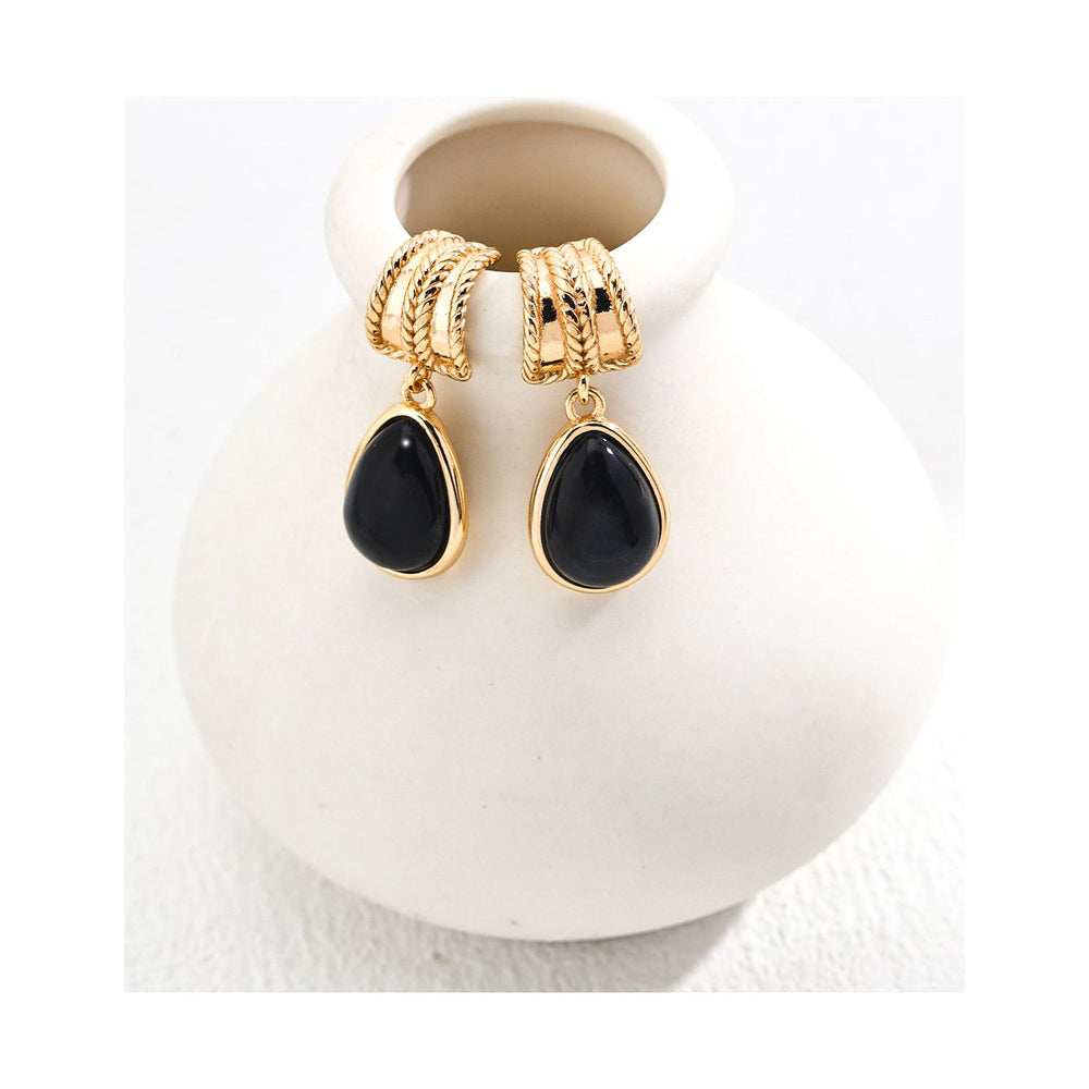 Gold drop earrings with glossy black stones, perfect for jewelry storage, jewelry websites, vintage jewelry collections, and gifting. Stylish and timeless design.