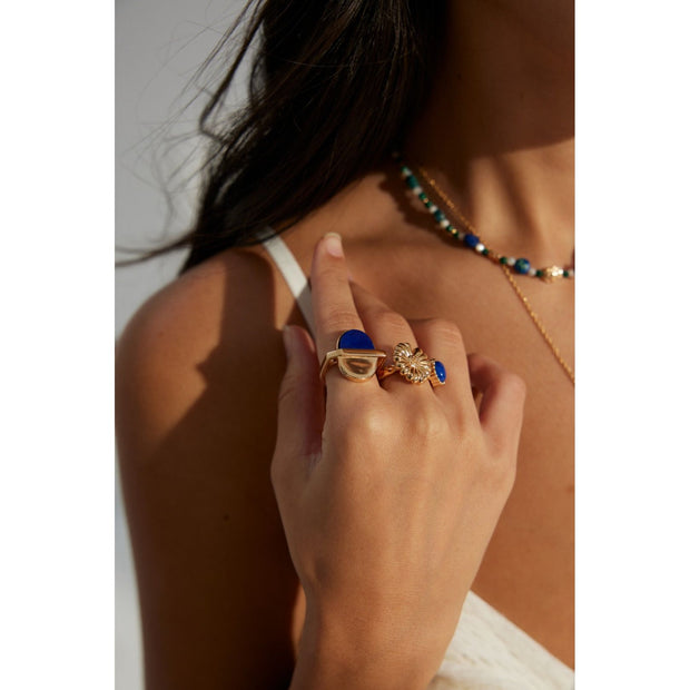 Elegant gold flower and blue gemstone rings on display – perfect for jewelry storage, designed by leading jewelry designers. Great addition to vintage jewelry collections, earrings rings sets, and jewelry with turquoise. Explore diamond and jewelry trends, body jewelry plus accessories, and name of jewelry stones for your personal or gift needs.