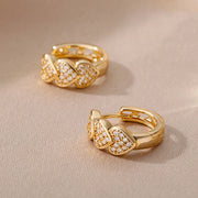Gold heart hoop earrings with sparkling crystals, perfect for jewelry websites, jewelry storage, diamond and jewelry collections, and gifting for mom.