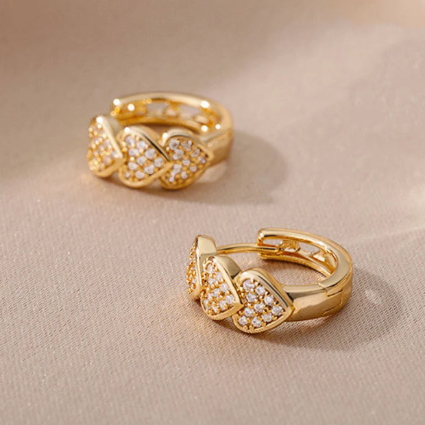 Gold heart hoop earrings with sparkling crystals, perfect for jewelry websites, jewelry storage, diamond and jewelry collections, and gifting for mom.