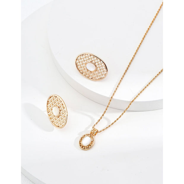 Gold oval pearl earrings with intricate lattice design on a white surface, ideal for vintage jewelry lovers, jewelry websites, and jewelry storage ideas. A perfect accessory for mature women hairstyles, earrings rings combinations, and showcasing gem jewelry or diamond and jewelry pieces.