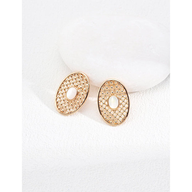 Gold oval pearl earrings with intricate lattice design on a white surface, ideal for vintage jewelry lovers, jewelry websites, and jewelry storage ideas. A perfect accessory for mature women hairstyles, earrings rings combinations, and showcasing gem jewelry or diamond and jewelry pieces.
