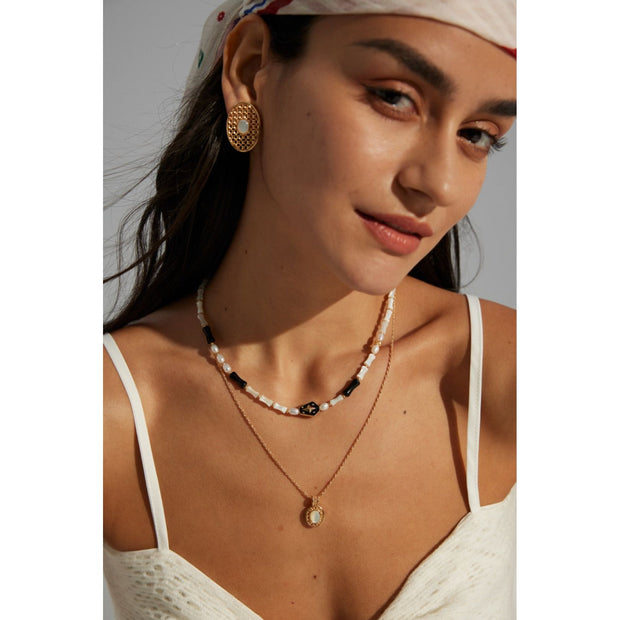 Gold oval pearl earrings with intricate lattice design on a white surface, ideal for vintage jewelry lovers, jewelry websites, and jewelry storage ideas. A perfect accessory for mature women hairstyles, earrings rings combinations, and showcasing gem jewelry or diamond and jewelry pieces.