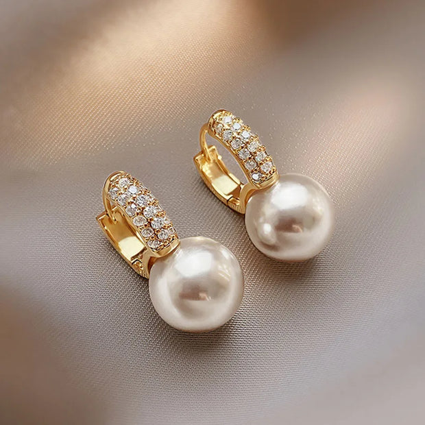 Gold hoop earrings with delicate pearls, ideal for jewelry storage, jewelry cleaning, and showcasing on jewelry websites by top jewelry designers for timeless style.