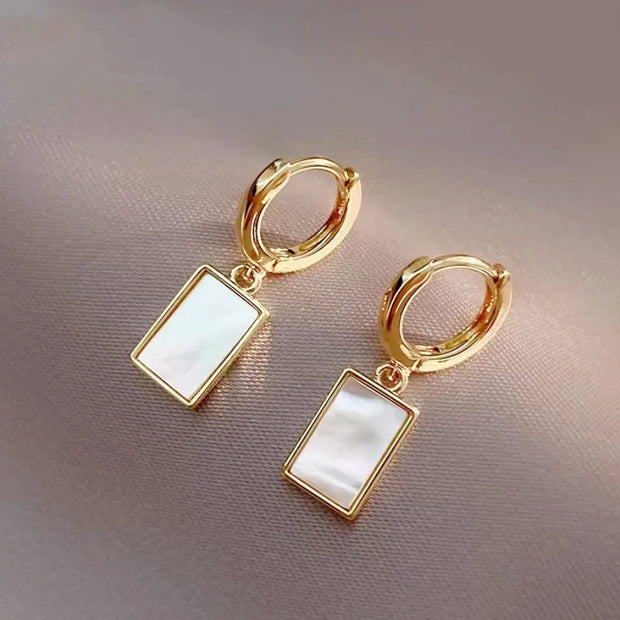 Gold hoop earrings with delicate pearls, ideal for jewelry storage, jewelry cleaning, and showcasing on jewelry websites by top jewelry designers for timeless style.