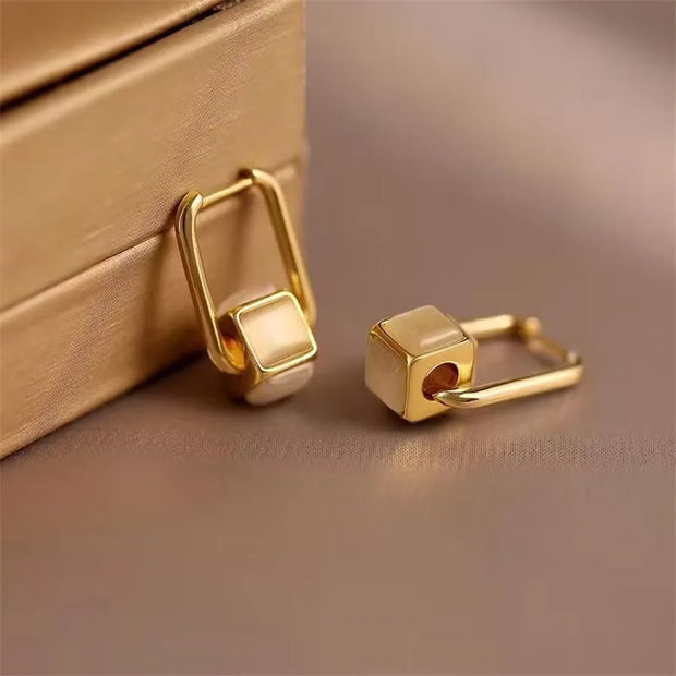 Gold hoop earrings with delicate pearls, ideal for jewelry storage, jewelry cleaning, and showcasing on jewelry websites by top jewelry designers for timeless style.