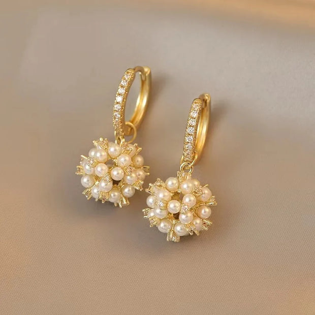 Gold hoop earrings with delicate pearls, ideal for jewelry storage, jewelry cleaning, and showcasing on jewelry websites by top jewelry designers for timeless style.
