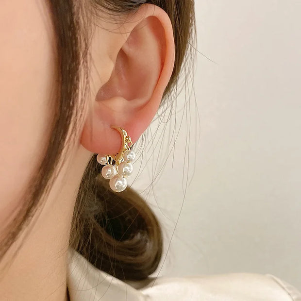 Gold hoop earrings with delicate pearls, ideal for jewelry storage, jewelry cleaning, and showcasing on jewelry websites by top jewelry designers for timeless style.