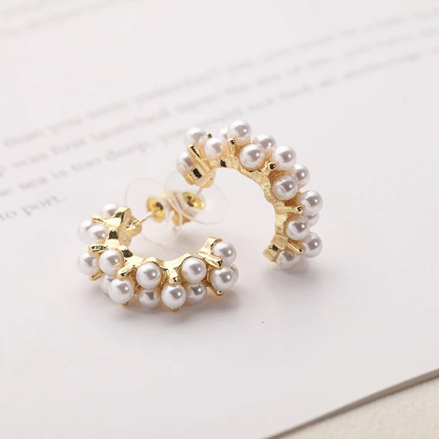 Gold hoop earrings with delicate pearls, ideal for jewelry storage, jewelry cleaning, and showcasing on jewelry websites by top jewelry designers for timeless style.