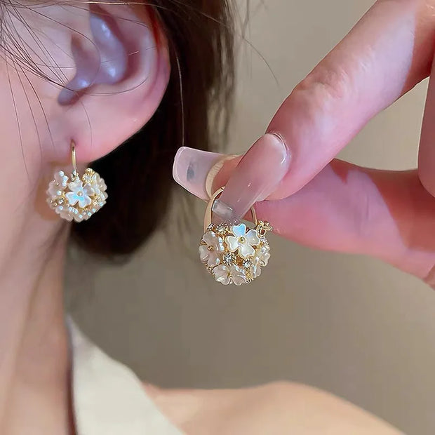 Gold hoop earrings with delicate pearls, ideal for jewelry storage, jewelry cleaning, and showcasing on jewelry websites by top jewelry designers for timeless style.