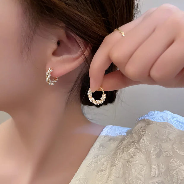 Gold hoop earrings with delicate pearls, ideal for jewelry storage, jewelry cleaning, and showcasing on jewelry websites by top jewelry designers for timeless style.