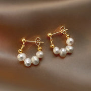Gold hoop earrings with delicate pearls, ideal for jewelry storage, jewelry cleaning, and showcasing on jewelry websites by top jewelry designers for timeless style.