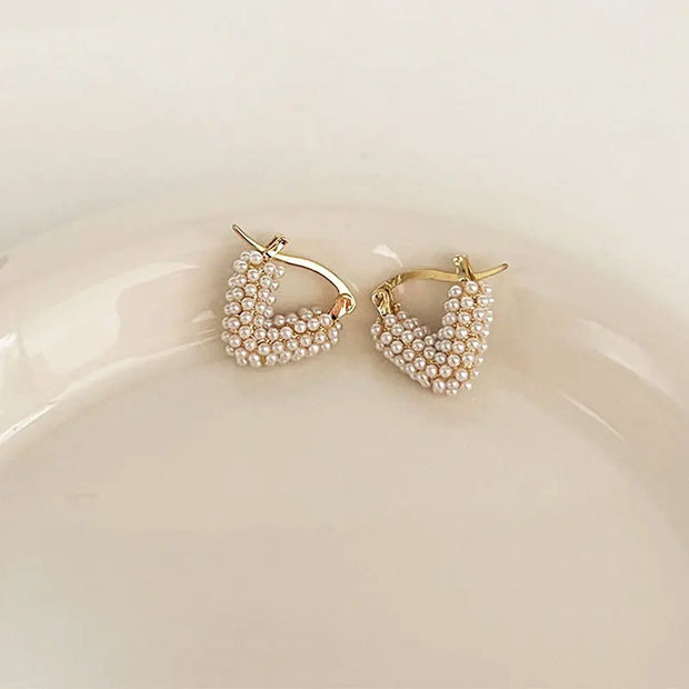 Gold hoop earrings with delicate pearls, ideal for jewelry storage, jewelry cleaning, and showcasing on jewelry websites by top jewelry designers for timeless style.