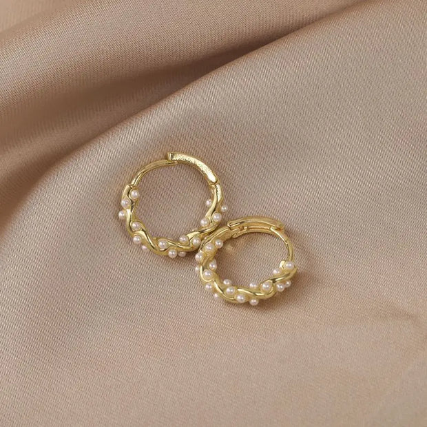 Gold hoop earrings with delicate pearls, ideal for jewelry storage, jewelry cleaning, and showcasing on jewelry websites by top jewelry designers for timeless style.