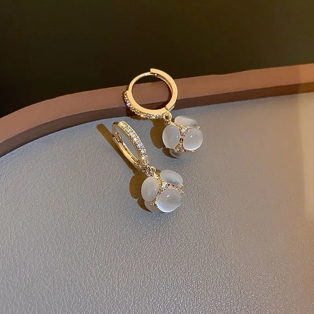 Gold hoop earrings with delicate pearls, ideal for jewelry storage, jewelry cleaning, and showcasing on jewelry websites by top jewelry designers for timeless style.
