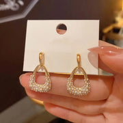 Gold hoop earrings with delicate pearls, ideal for jewelry storage, jewelry cleaning, and showcasing on jewelry websites by top jewelry designers for timeless style.