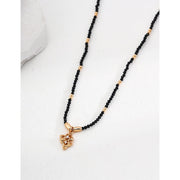 Gold pendant black beaded necklace, perfect for jewelry storage, jewelry websites, vintage jewelry collections, and as a timeless accessory for all occasions.