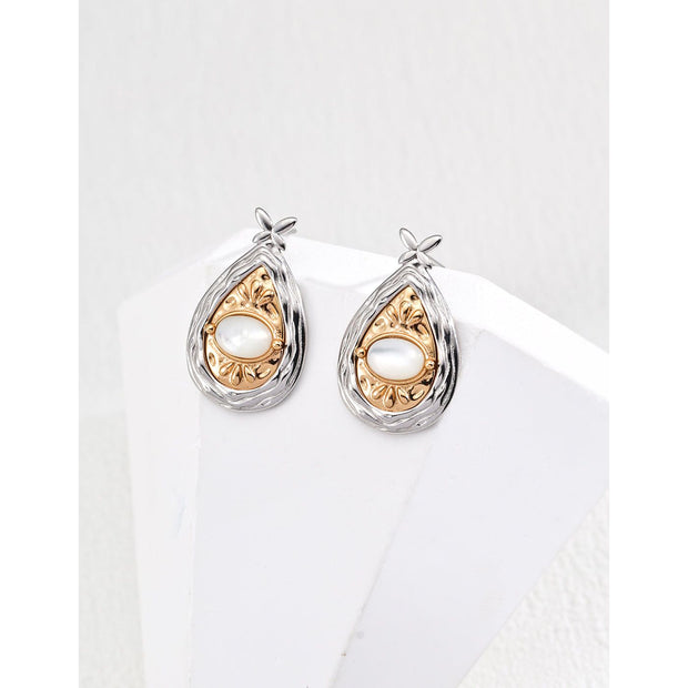 Gold and silver teardrop pearl earrings with intricate detailing, perfect for vintage jewelry lovers, jewelry designers, and jewelry websites. Ideal for jewelry storage, pairing with mature women hairstyles, and showcasing gem jewelry or diamond and jewelry collections.